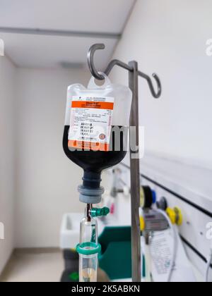 Nahaufnahme eines IV-Plastikbeutels mit Tropfkammer im Aufwachraum auf der Intensivstation des Krankenhauses mit Bokeh-Hintergrund. Keine Menschen. Stockfoto