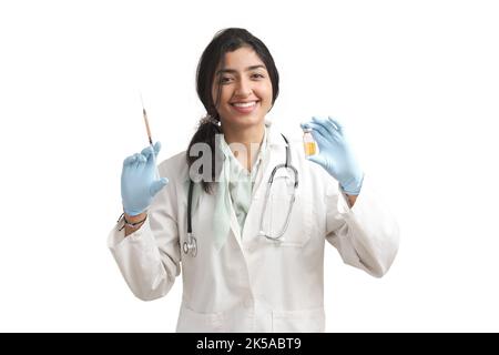 Junge venezolanische Ärztin mit einer Spritze und einem Fläschchen, isoliert. Stockfoto