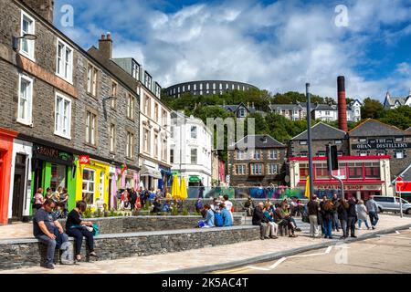 Oban, Schottland, Großbritannien - 29. Juli 2015: Die farbenfrohen Geschäfte und Cafés am Wasser von Oban, in denen Touristen einen Sommertag genießen. Zeigt lokale Wahrzeichen von t Stockfoto