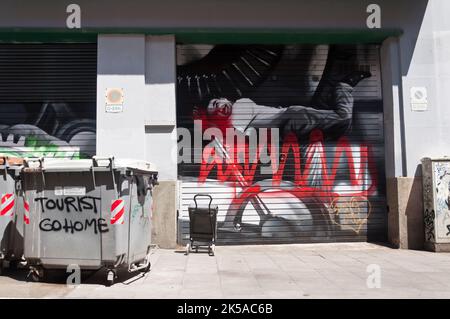 Zerstörte Graffiti von Charlot und einen Protest gegen den Tourismus im Bezirk Gracia, Barcelona, Spanien.