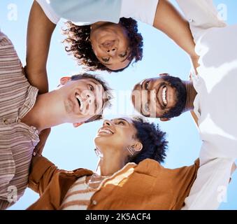 Freunde, Teamarbeit und glücklich mit einer Mann-Frau-Gruppe, die in Solidarität draußen in einem Kreis oder Kreis auf einem blauen Himmel von unten steht. Lächeln, Vertrauen und Stockfoto