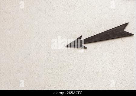 Holzpfeilzeiger nach links unten auf hellem Hintergrund Stockfoto
