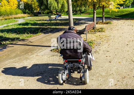 Alter Mann mit Rollstuhl im Park Stockfoto