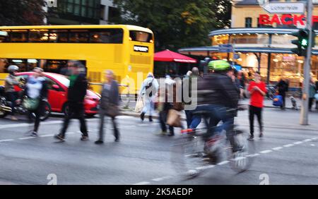 Berlin, Deutschland. 06. Oktober 2022. 06.10.2022, Berlin. Im dichten abendlichen Rushhour-Verkehr überqueren Fußgänger vor dem Rathaus von Steglitz eine Ampel. Ein Bus der BVG steht unterdessen im Hintergrund an einer Bushaltestelle. Aufnahme mit langer Belichtungszeit. Quelle: Wolfram Steinberg/dpa Quelle: Wolfram Steinberg/dpa/Alamy Live News Stockfoto