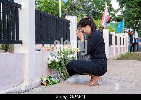 7. Oktober 2022: Eine Frau betet vor dem Eingang des Kinderzentrums Uthai Suwan in der thailändischen Provinz Nong Bua Lamphu. Der Angreifer benutzte eine Kombination aus Gewehren und Messern, um mindestens 38 Menschen in der Kindertagesstätte zu töten, wobei die meisten der Opfer kleine Kinder waren. (Bild: © Adryel Talamantes/ZUMA Press Wire) Stockfoto