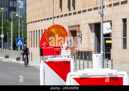 Rot-weiße Straßensperren mit Taschenlampe zur Sicherung von Baustelle, Baustelle, Straße im Bau. Temporäre Zäune, Reparatur auf der Stadt Stockfoto