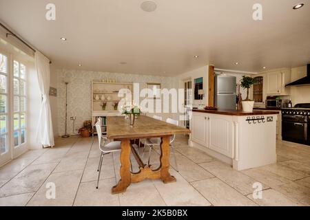 Modernes Esszimmer mit offener Küche und traditioneller Einrichtung und Möbeln Stockfoto