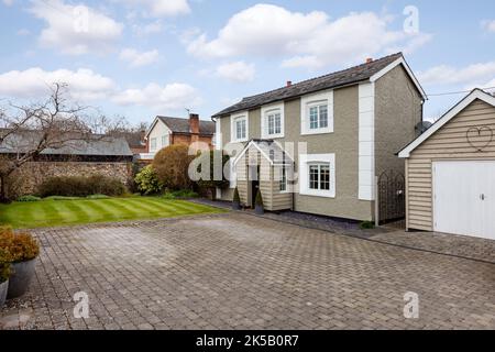 Freistehendes traditionelles Ferienhaus mit gepflasterter Auffahrt und Garage Stockfoto