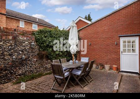 Ummauerter Garten im Innenhof mit Tisch und Stühlen Stockfoto