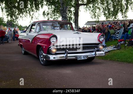 Ein Oldtimer Ford Fairlane Crown Victoria in Pink mit runden Scheinwerfern im Park Stockfoto