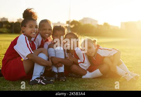 Mädchen Kinder, Fußballplatz und Team-Portrait zusammen für Wettbewerb, Spiel und Sommertraining im Freien in Brasilien. Fußballverein, glückliche kleine Kinder Stockfoto