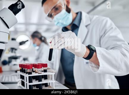 Covid, Wissenschaft und Blut mit Arzt im Labor mit einer Gesichtsmaske, an Impfstoff, medizinische und Forschungsuntersuchungen arbeiten. Innovation, Gesundheitswesen Stockfoto