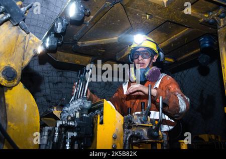 Bergmann betreibt einen Jumbo-Bohrer in einer Untertagemine Stockfoto