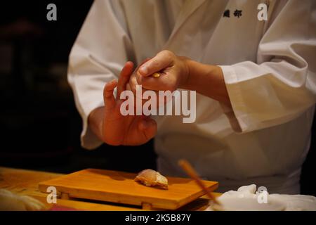 Eine Nahaufnahme eines Küchenchefs, der Sushi zubereitet Stockfoto