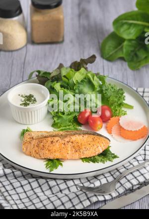 Gebratene Lachssteaks mit Gemüse Bio auf Holztisch Stockfoto