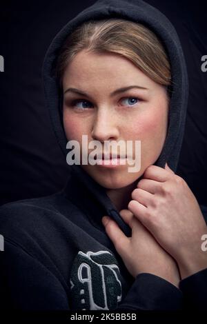 Nahaufnahme einer jungen Frau mit schwarzer Kapuze Stockfoto