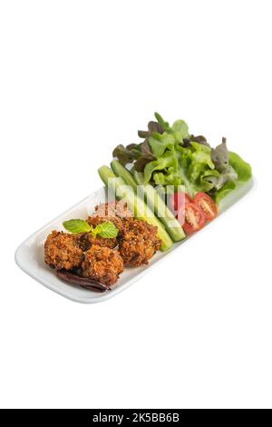 Gebratener Schweinchen-Larb (LAB tod) in langen Tellern mit Gemüseseitensorten auf Holzhintergrund Draufsicht auf weißem Hintergrund isoliert. Würzige thailändische Gerichte aus Isan Stockfoto