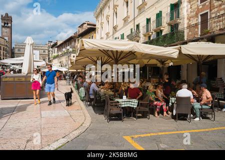 Piazza delle Erbe, Blick im Sommer von Menschen sitzen vor Cafés und Bars auf der Piazza delle Erbe im historischen Zentrum von Verona, Italien Stockfoto