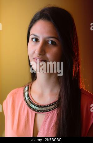 Porträt einer jungen Frau mit klarem Gesicht auf goldenem Hintergrund. Stockfoto