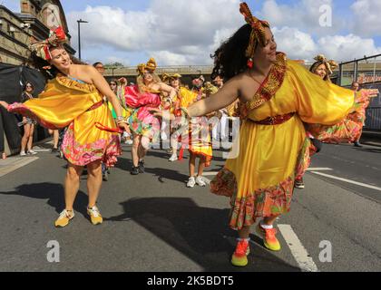 Eine Tanzgruppe in bunten Kostümen nimmt an der Familienparade, Notting Hill Carnival, London, Teil Stockfoto