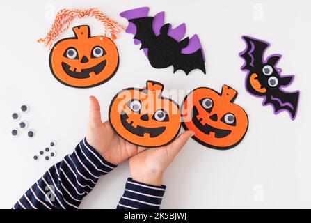 Kinderhände halten halloween Kürbis Dekorationen mit gruseligen Gesicht Stockfoto