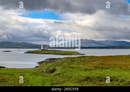 Eilean Musdile Lighthouse und die Isle of Mull aus Lismore, Schottland Stockfoto