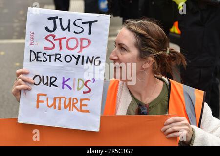 London, Großbritannien. 07. Oktober 2022. Eine Protesterin hält ein Plakat, das ihre Meinung während des Protestes gegenüber der Downing Street in Whitehall zum Ausdruck bringt. Die Klimaaktivisten-Gruppe Just Stop Oil protestieren am 7.. Tag der Occupy Westminster-Aktion, in der sie fordern, alle zukünftigen Lizenzen einzustellen und der Exploration, Entwicklung und Produktion fossiler Brennstoffe in Großbritannien zu zustimmen. Kredit: SOPA Images Limited/Alamy Live Nachrichten Stockfoto