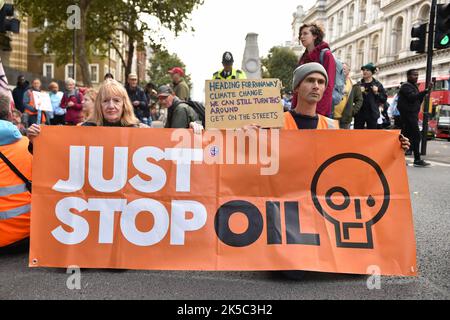 London, Großbritannien. 07. Oktober 2022. Demonstranten halten ein Transparent, das ihre Meinung während des Protestes gegenüber der Downing Street zum Ausdruck bringt. Die Klimaaktivisten-Gruppe Just Stop Oil protestieren am 7.. Tag der Occupy Westminster-Aktion, in der sie fordern, alle zukünftigen Lizenzen einzustellen und der Exploration, Entwicklung und Produktion fossiler Brennstoffe in Großbritannien zu zustimmen. Kredit: SOPA Images Limited/Alamy Live Nachrichten Stockfoto