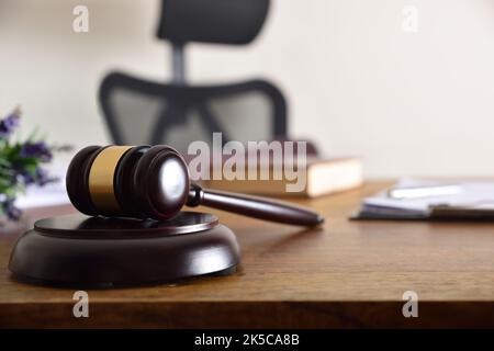 Gavel auf dem Schreibtisch eines Richters oder Anwalts mit Dokumenten und Büchern im Hintergrund. Vorderansicht Stockfoto