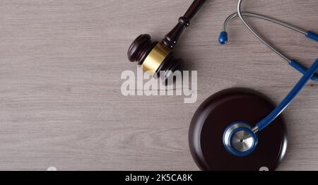 Konzept Hintergrund der Gerechtigkeit in Gesundheit und Gesundheit in fairer Gerechtigkeit mit Gavel und Stethoskop auf Holztisch. Draufsicht. Stockfoto