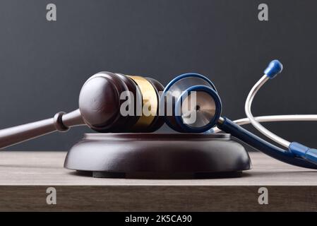 Faires Konzept der sozialen Gerechtigkeit mit Gavel und Stethoskop auf Holztisch. Vorderansicht. Stockfoto
