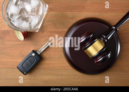 Gavel, Autoschlüssel und Glas mit Alkohol auf Holztisch und schwarzem isolierten Hintergrund. Konzeptstudie für das Fahren mit Alkoholsatz nicht erlaubt. Draufsicht Stockfoto