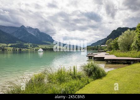 Blick über den Walchsee, Seeufer mit Badesteg, links das Kaisergebirge mit dem Zahmen Kaiser, Walchsee, Kaiserwinkl, Kreis Kufstein, Tirol, Österreich Stockfoto