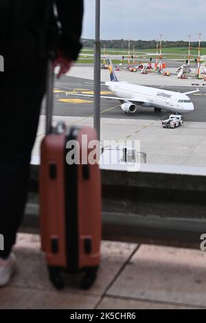 Hamburg, Deutschland. 07. Oktober 2022. Eine Frau steht mit ihrem Koffer auf der Aussichtsplattform und blickt auf den Flugplatz vor Terminal 1. Während der Herbstferien, die dieses Wochenende in Hamburg, Schleswig-Holstein und Mecklenburg-Vorpommern beginnen, werden einige Flugreisende am Hamburg Airport Geduld üben müssen. Quelle: Jonas Walzberg/dpa/Alamy Live News Stockfoto