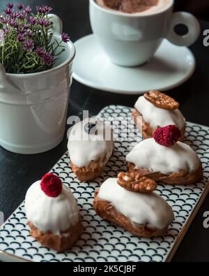 Traditionelles französisches Dessert: Im Café oder Restaurant werden weiße Schokolade auf einem schwarzen Tisch serviert. Heiße Schokolade und Tee in der Nähe. Stockfoto