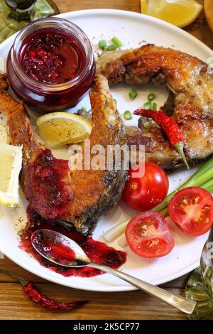 Gebratener Karpfen mit Tkemali und Weißwein Stockfoto