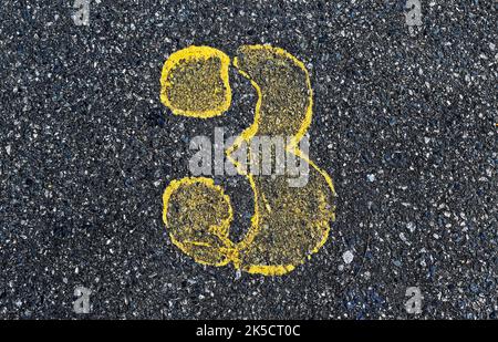 Nummer 3 in gelb auf Asphaltboden lackiert Stockfoto