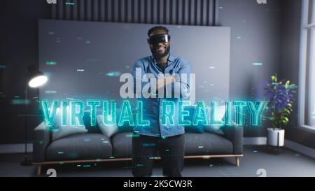 Ein junger schwarzer Mann nutzt eine Virtual-Reality-Brille und taucht in die virtuelle Welt ein. Neue Technologien. Unterhaltung der Zukunft Stockfoto