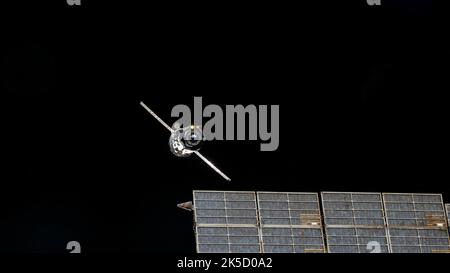Das Versorgungsschiff Progress 79 von Roscosmos verlässt die Internationale Raumstation, nachdem es vom hinteren Hafen des Zvezda-Servicemoduls abgedockt wurde, wobei eine von Zvezdas Solararrays im Vordergrund sichtbar ist. Stockfoto