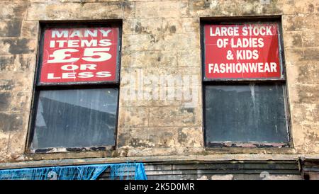 Heruntergekommene verfallene Gebäude-Werbefenster, die Armut repräsentieren, und gescheiterte Shopping-Venture-Schilder Paisley, Schottland, Großbritannien Stockfoto