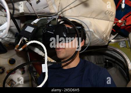 Der NASA-Astronaut und Expediiton 66-Flugingenieur Raja Chari trägt eine Virtual-Reality-Brille, um Rettungsszenarien für den Außeneinsatz zu üben, die beim Manövrieren mit dem sicheren Jet-Pack des US-Weltraumfahrzeugs, auch bekannt als Simplified Aid for EVA Rescue, zum Einsatz kommen würden. Stockfoto