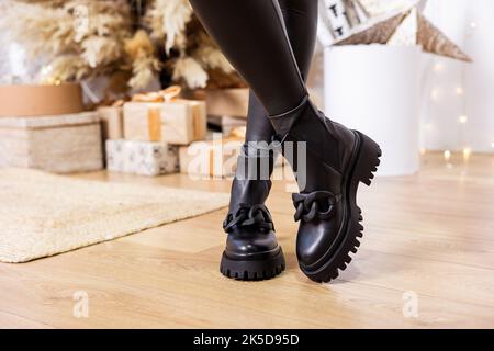 Schwarze chelsea Damenstiefel aus echtem Leder mit Schnalle. Neue Kollektion von Winterschuhen für stilvolle Mädchen Stockfoto