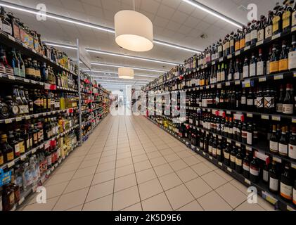 Fossano, Italien - 09. September 2022: Gang mit Regalen mit Flaschen Wein und Spirituosen zum Verkauf im italienischen Supermarkt Mercatò Stockfoto