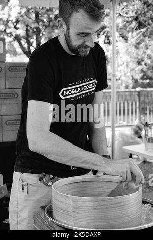 Ein Handwerker kreiert beim Lowell Folk Festival im historischen Lowell, Massachusetts, eine wunderschöne Trommel von Hand. Das Bild wurde auf Schwarzweiß A aufgenommen Stockfoto