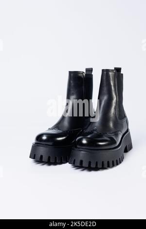 Schwarze Damenstiefel mit echtem Leder auf einer rauen Sohle ohne Schnürsenkel. Neue Kollektion von Damenfrühlingsschuhen Stockfoto