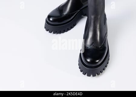 Schwarze Damenstiefel mit echtem Leder auf einer rauen Sohle ohne Schnürsenkel. Neue Kollektion von Damenfrühlingsschuhen Stockfoto