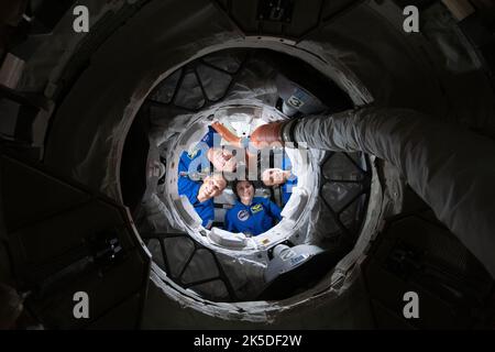 Expedition 67 Flight Engineers (von unten im Uhrzeigersinn) Samantha Cristoforetti, Bob Hines, Kjell Lindgren und Jessica Watkins lächeln für ein Porträt aus dem Inneren des Boeing CST-100 Starliner-Crew-Schiffes. Das Quartett blickt durch den vorwärtsgerichteten internationalen Docking-Adapter des Harmony-Moduls, an den Starliner angedockt ist, und in die Internationale Raumstation. Stockfoto