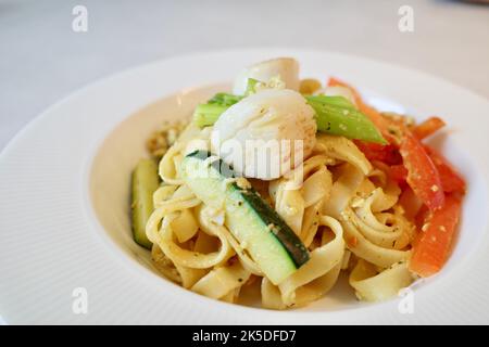 Gebratene Nudeln mit Jakobsmuscheln und Gemüse. Es ist eine gemeinsame hausgemachte Küche in vielen asiatischen Ländern wie China, Taiwan und Thailand. Stockfoto