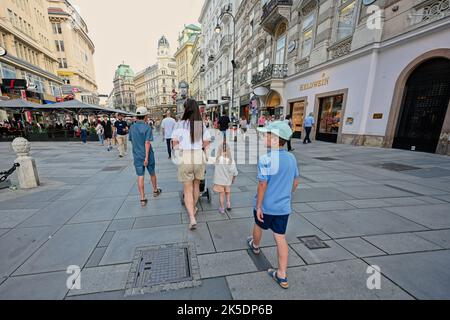 Wien, Österreich - 17. Mai 2022: Mutter mit Kindern in der Wiener Hauptstraße. Stockfoto
