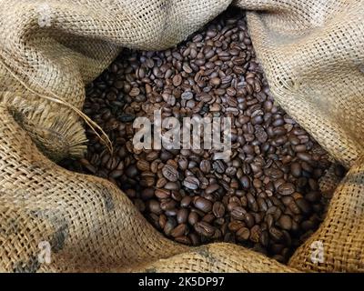 Braune Kaffeebohnen im Sackleinen Makro-Nahaufnahme Stockfoto